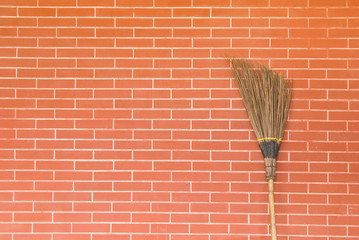 broom on brick wall