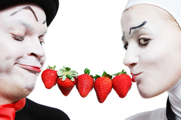 Couple of mimes with the strawberry on a white background