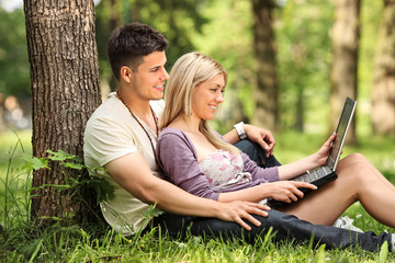 A boyfriend and girlfriend working on a laptop