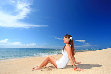 砂浜に座り海を眺める女性