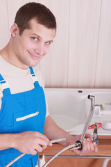 Obraz premium Plumber fitting a kitchen tap