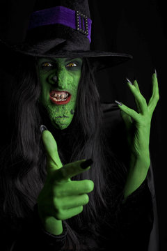 Evil witch, black background.