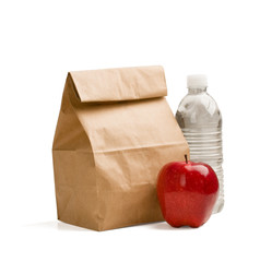 Brown lunch bag, red apple and bottle of water isolated on white