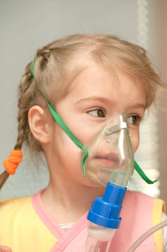 A little girl three years doing inhalation