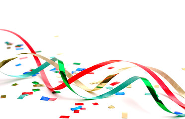 Colorful holiday streamers and confetti on white background
