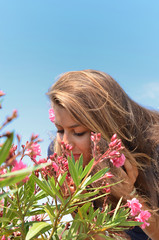 Portrait d'une jeune femme qui sent les parfums des plantes