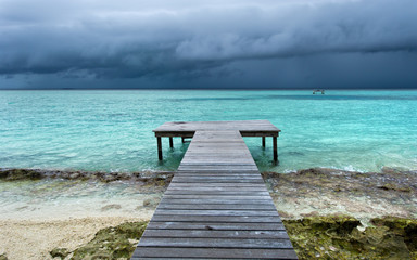 Obraz premium wooden bridge on beach extended into the sea