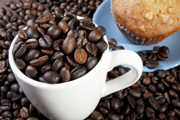 coffee beans in a cup with peice of bakery.