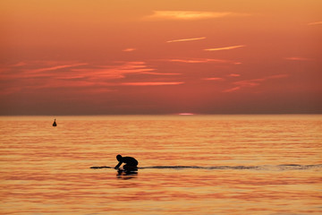 Surfer in the water at sundown