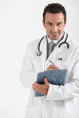 Fototapeta premium Doctor writing on clipboard smiling