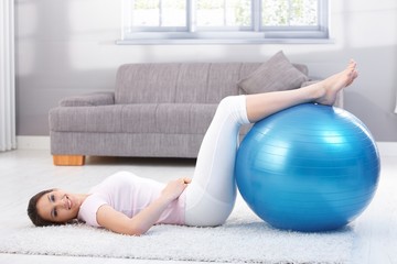 Beautiful woman doing fit ball exercise smiling
