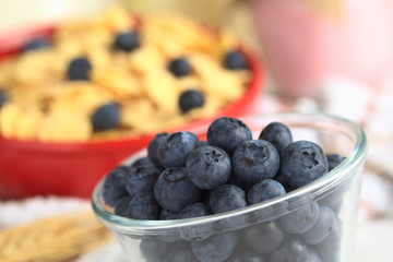 Blueberries in glass bowl with cereal and yogurt