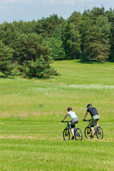 Sport mountain couple biking downhill sunny meadows