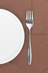Fork and dish on a napkin as a dining room serving.