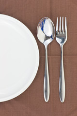 Spoon and fork on a napkin as a dining room serving.