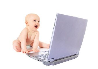 Fröhliches Baby sitzt am Laptop