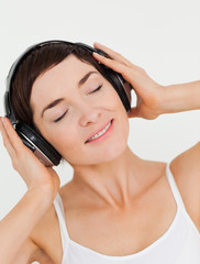 Naklejka premium Portrait of a charming brunette listening to music