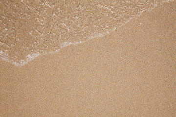 Fototapeta na wymiar Wave of water on sandy beach