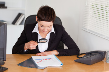 Woman looking at a chart with a magnifying glass