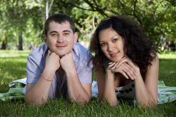 couple lays together on a grass