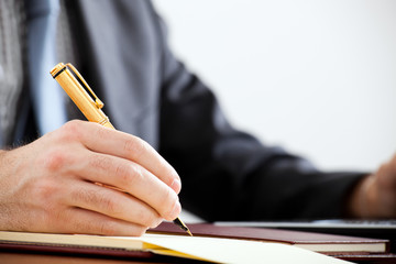 Businessman writing a document in his office