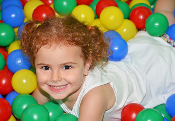 Fototapeta na wymiar Bambina che gioca con palline colorate