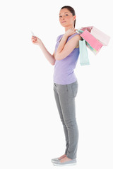 Good looking woman with a credit card holding shopping bags whil