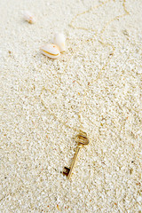 vintage golden key on the sand beach