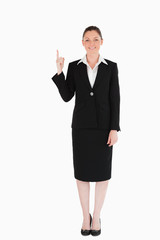 Good looking female in suit pointing at a copy space