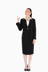 Attractive female in suit pointing at a copy space