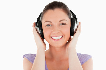 Naklejka premium Portrait of a good looking woman posing with headphones while st