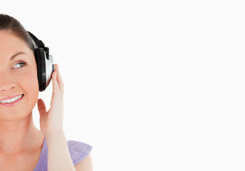 Portrait of a charming woman posing with headphones while standi