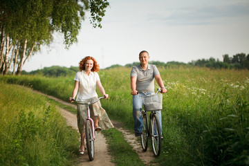 Happy young couple riding on a bicycles