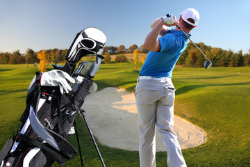 Man playing golf with golf bag