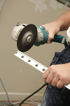 homme utilisant disqueuse pour couper corni&egrave;re d'angle