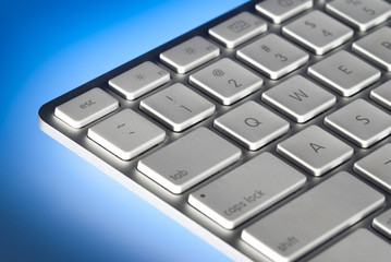 Computer keyboard close-up back lit by blue light