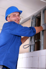 Electrician wiring a large tiled room