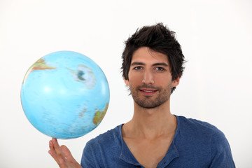 Man spinning a globe on his fingertips