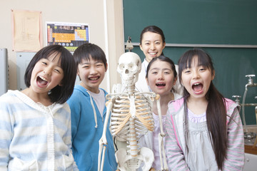 骨格模型で遊ぶ小学生男女と女性教師