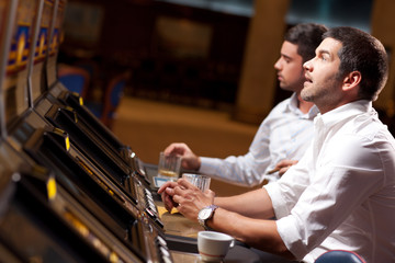 handsome men playing the slot machine
