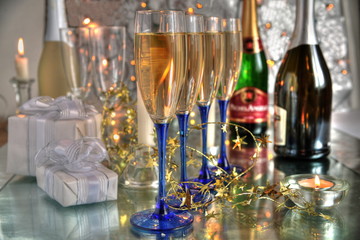 Champagne in glasses,gifts and lights on silver background.