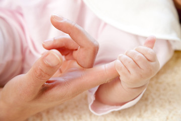 Fototapeta na wymiar 母親の小指を掴む赤ちゃんの手元