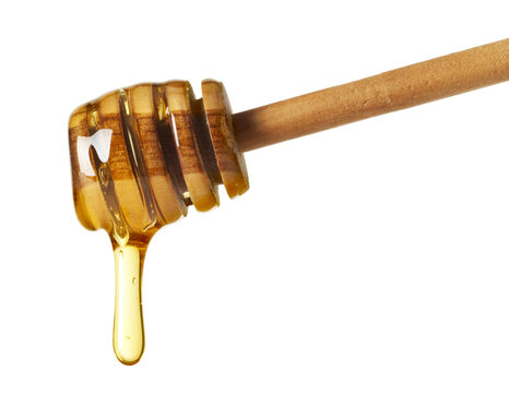 honey dripping from wooden drizzler