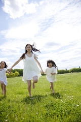 Naklejka na ściany i meble 草原を走る女の子2人と若い女性