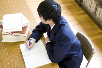 図書室で勉強する男子中学生