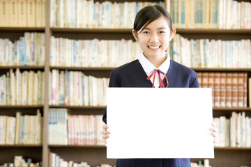 図書室でメッセージボードを持っている女子中学生