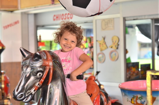 bambina sulle giostre