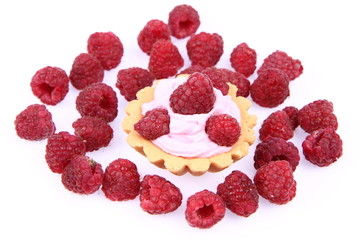 Tartlet with whipped cream and raspberries on white background