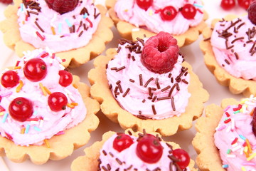 Tartlets with whipped cream, fruits and sprinkles