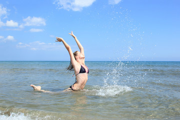 Beautiful woman jumps out of the sea